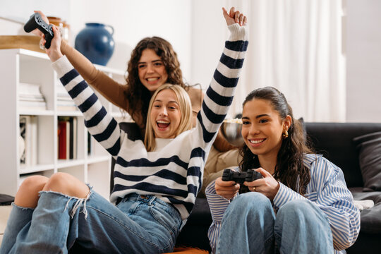 Friends joyfully play digital games together while saving money with discounted gift cards.